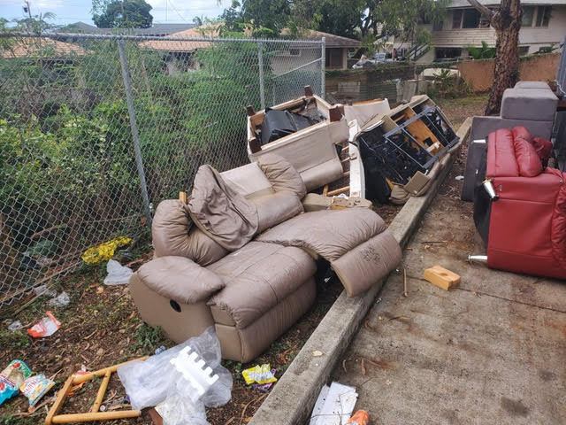 Sidewalk with old couches that is need of cleanout service by Oahu Dump Run